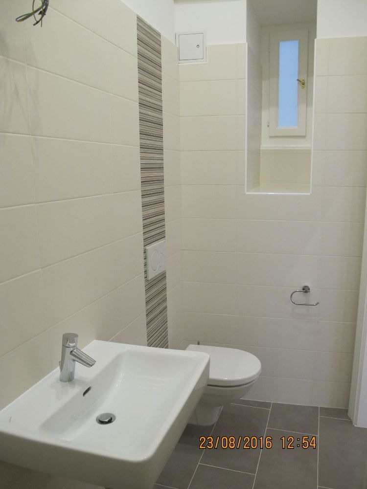 Ein Badezimmer mit Waschbecken, Toilette und Fenster