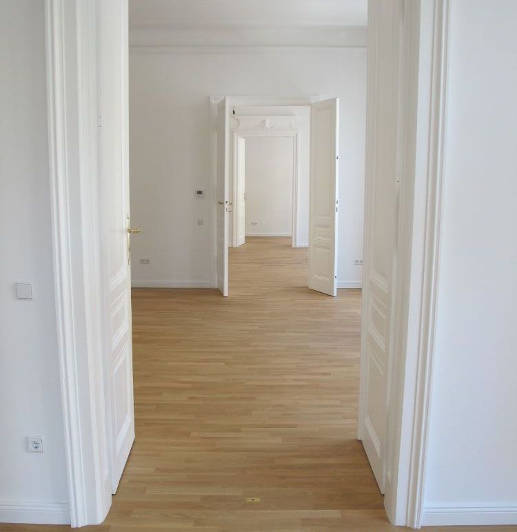 Ein leerer Raum mit Hartholzböden und weißen Wänden.