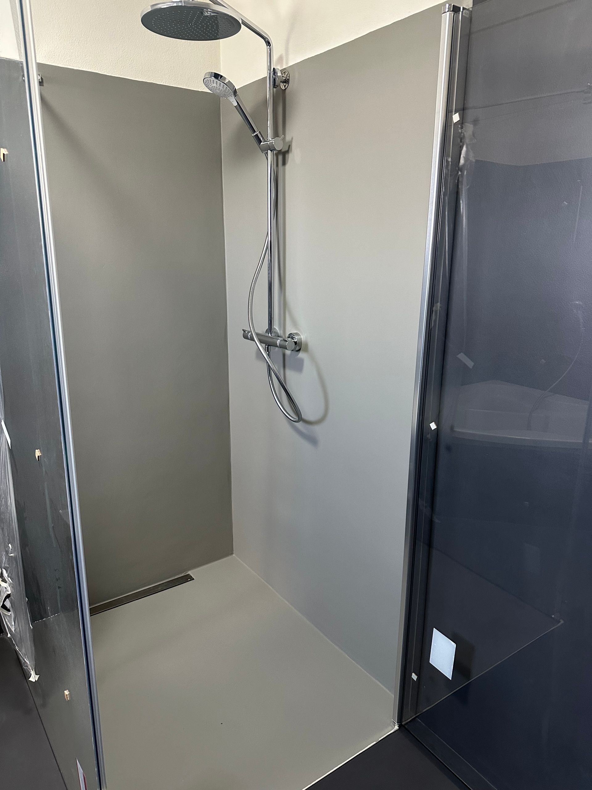 Ein Badezimmer mit ebenerdiger Dusche und Duschkopf.