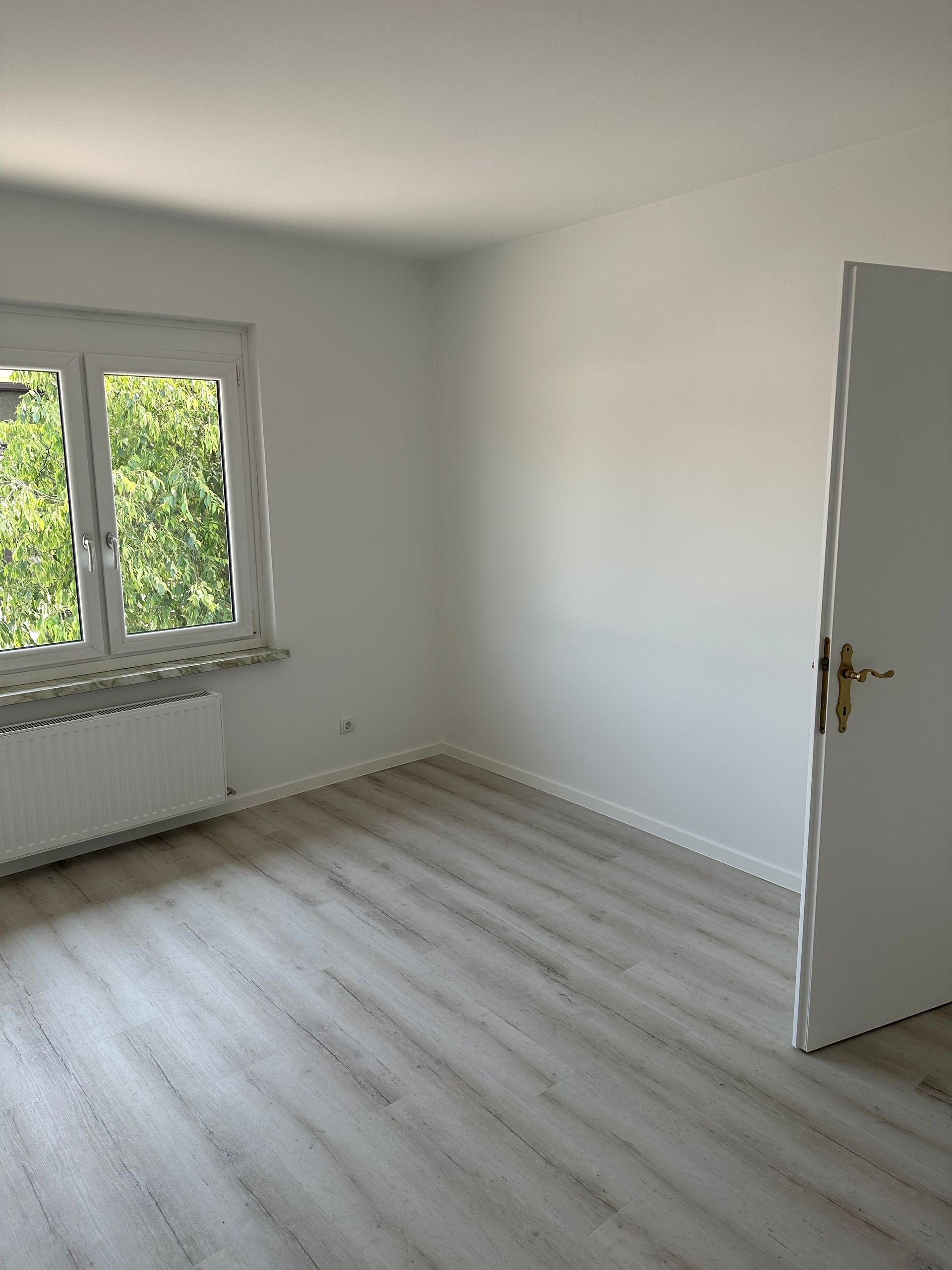 Ein leerer Raum mit einem Fenster und einer Tür