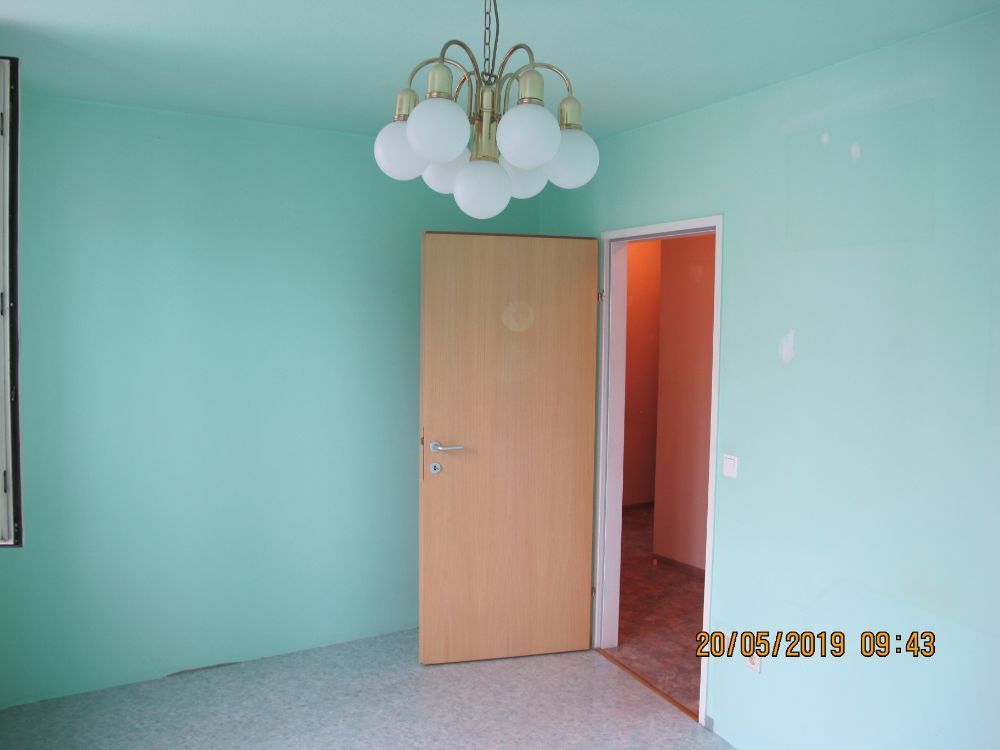 Ein Bild von einem leeren Raum mit einer Mintgrünen Wand