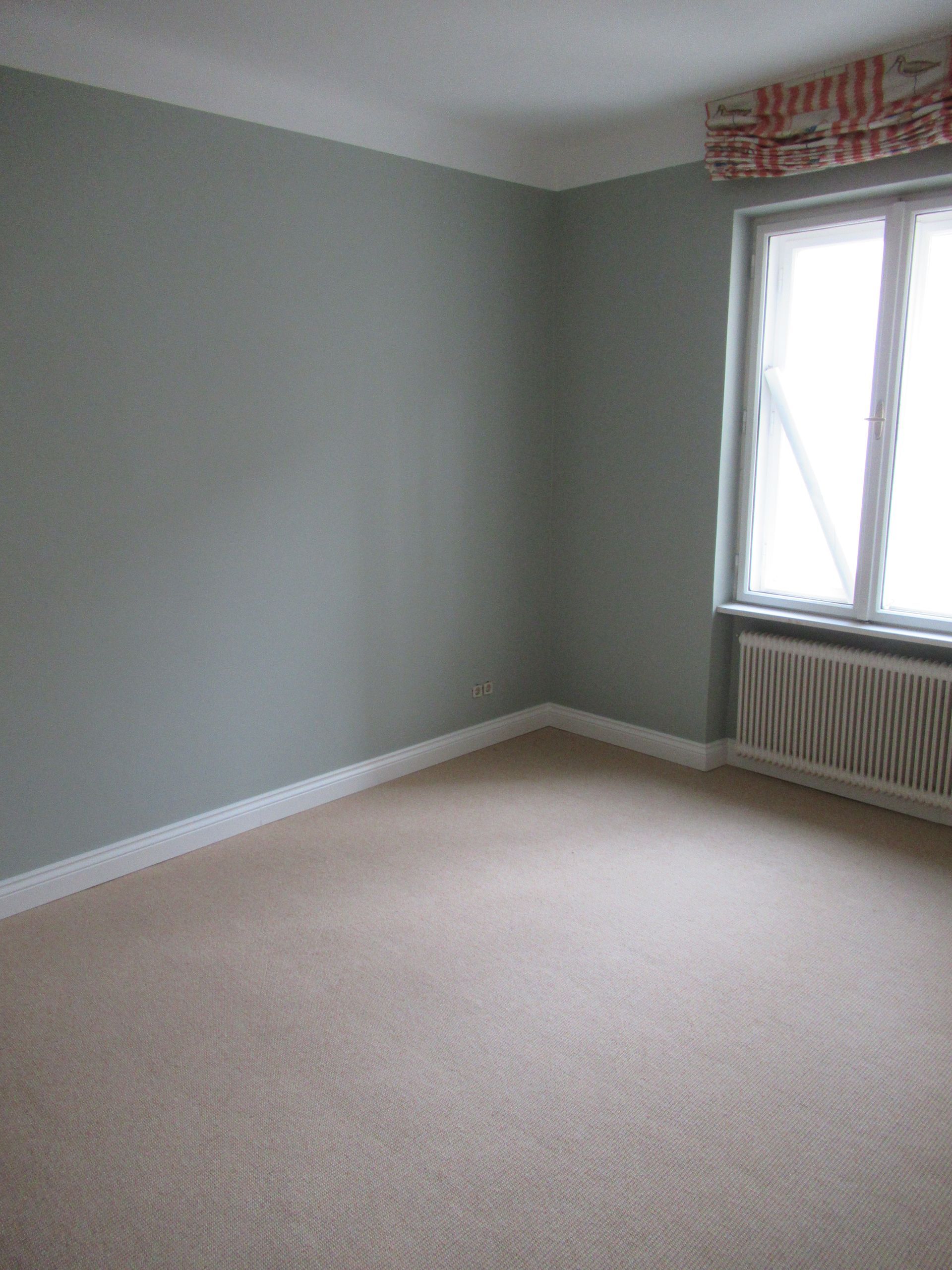 Ein leerer Raum mit einem Fenster und einem Heizkörper