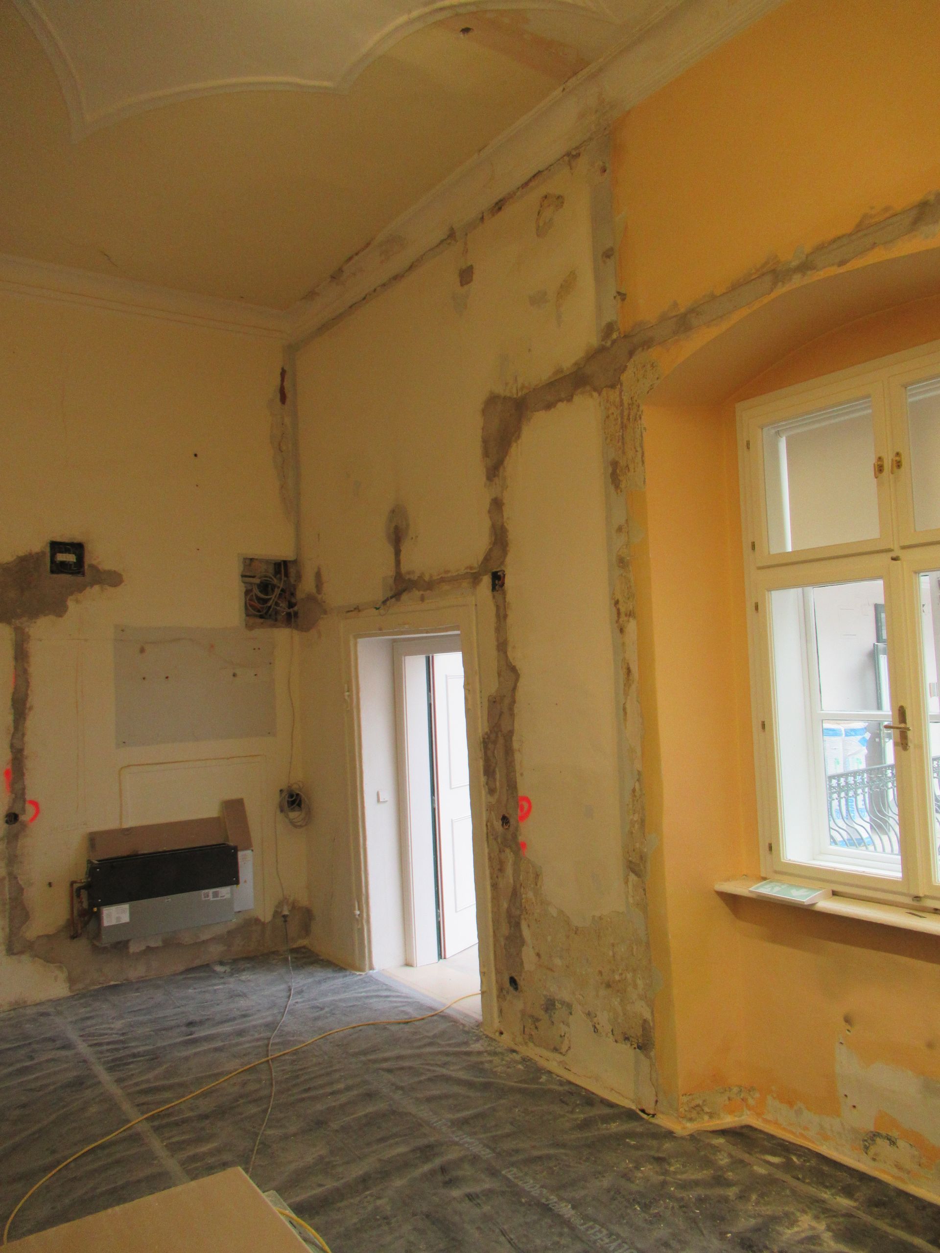 Ein leerer Raum mit einem Fenster und einer Tür.