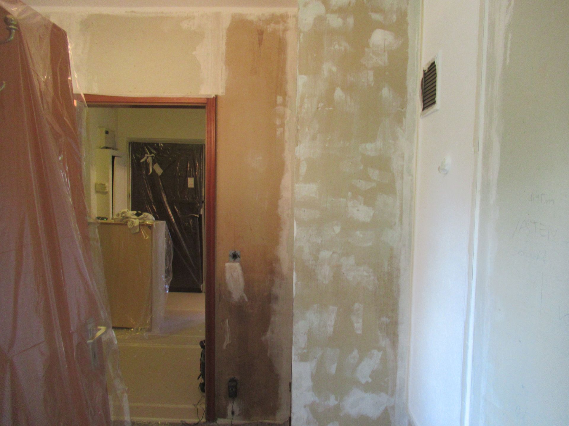 Ein Badezimmer mit Badewanne und einer mit Kunststoff verkleideten Tür.