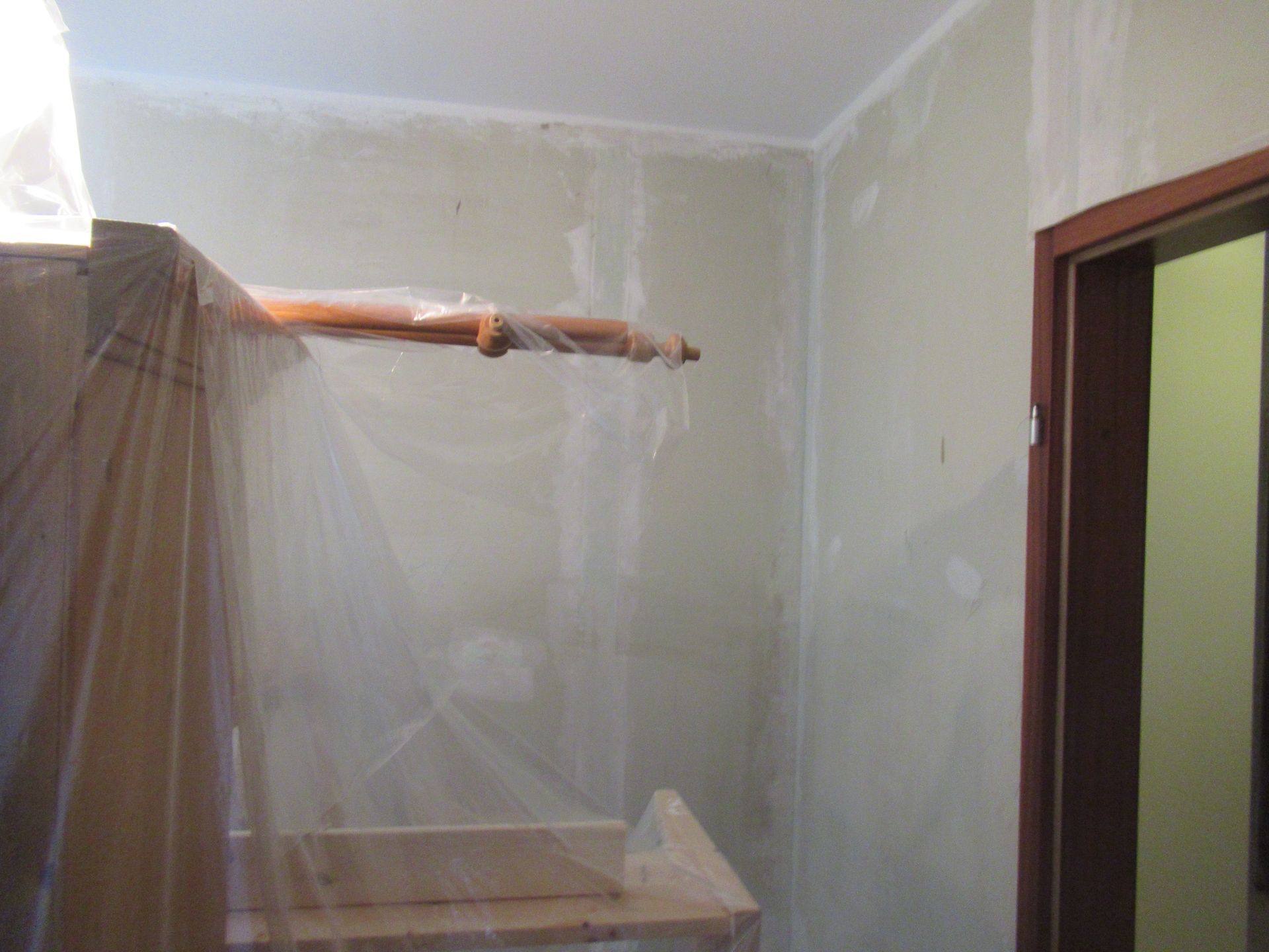 Ein Raum mit einer Plastikfolie an der Wand und einer Tür