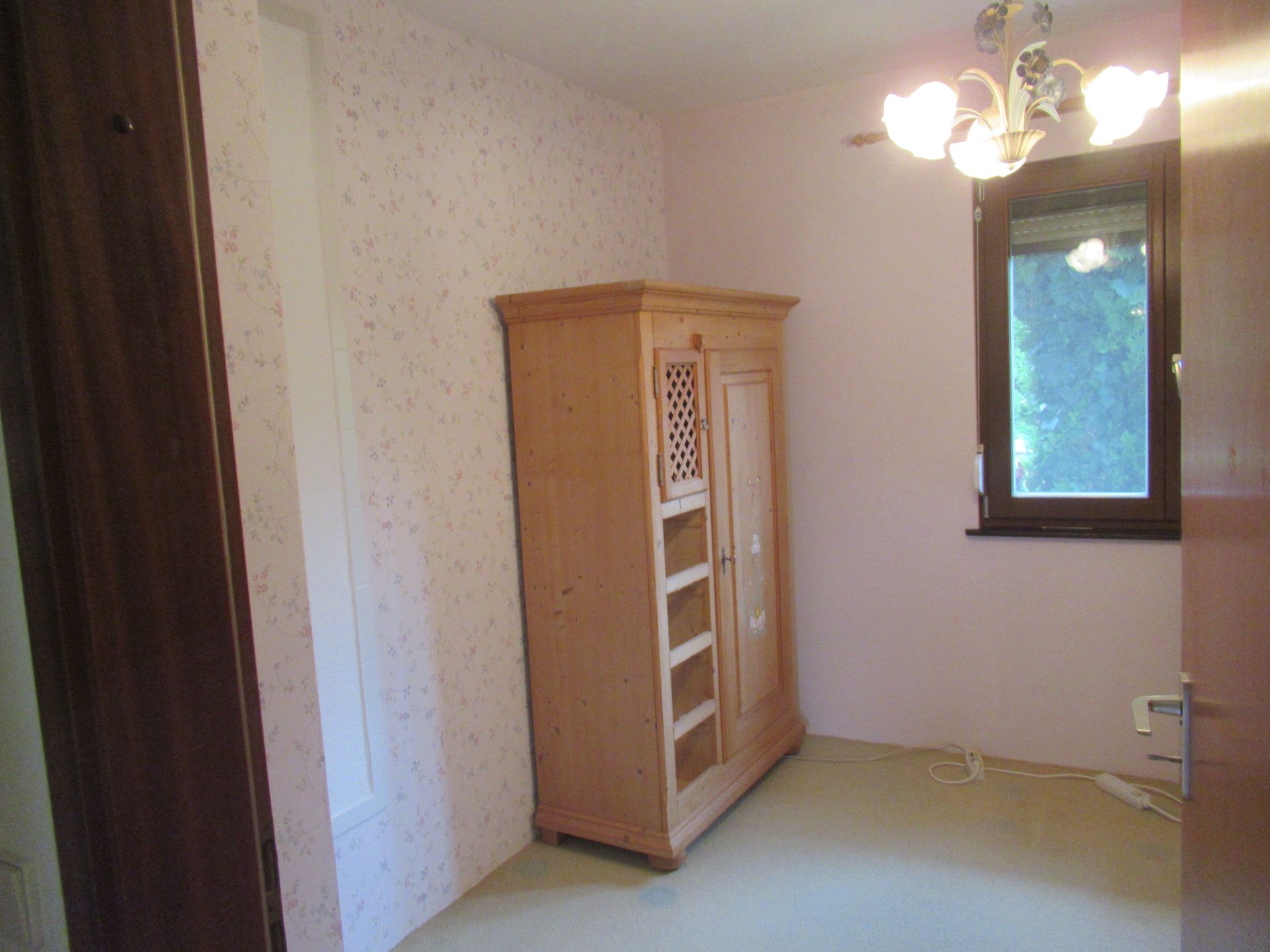 Ein leerer Raum mit Holzboden und weißen Wänden