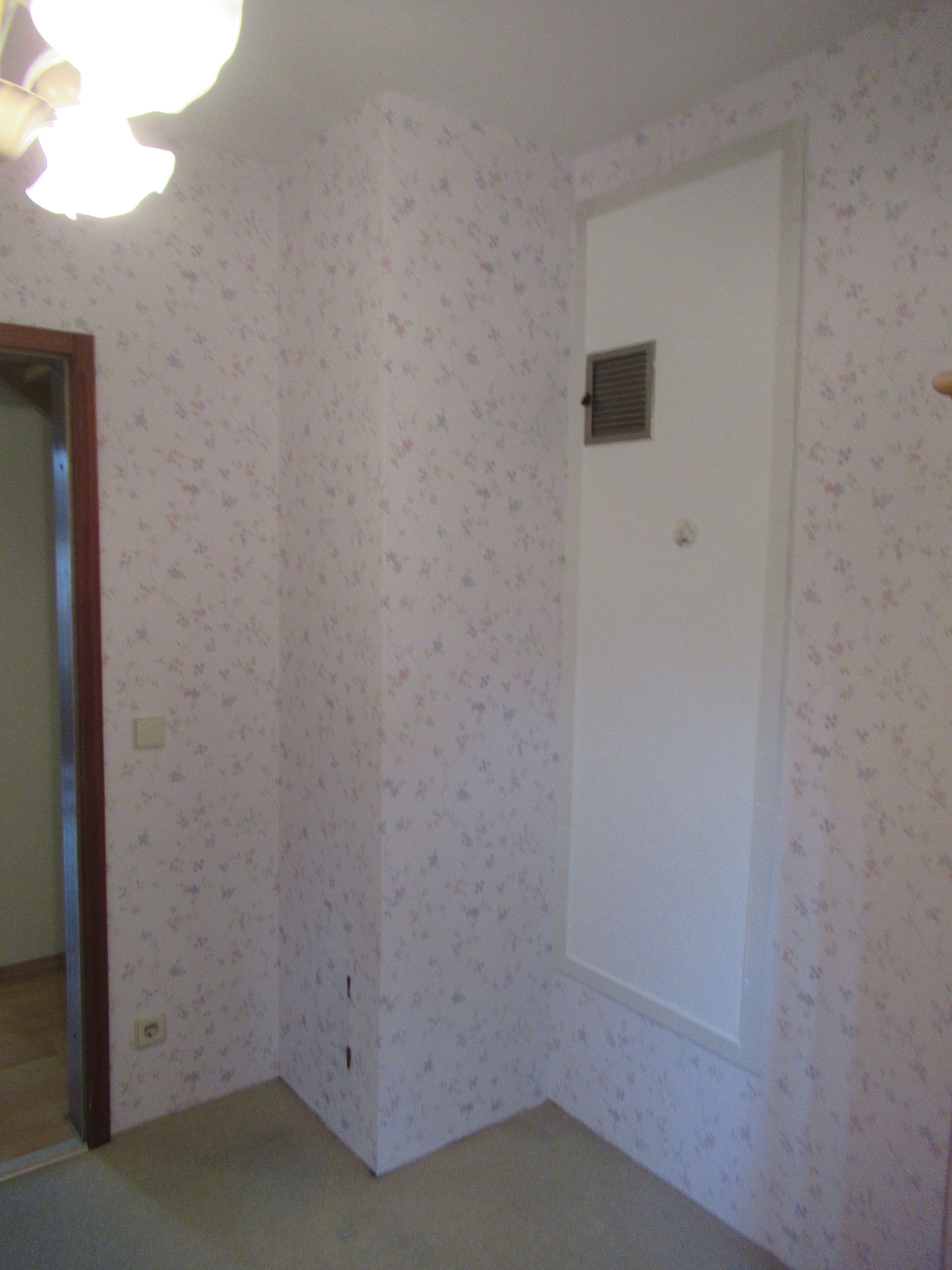 Ein leerer Raum mit weißen Wänden und einem Deckenventilator.