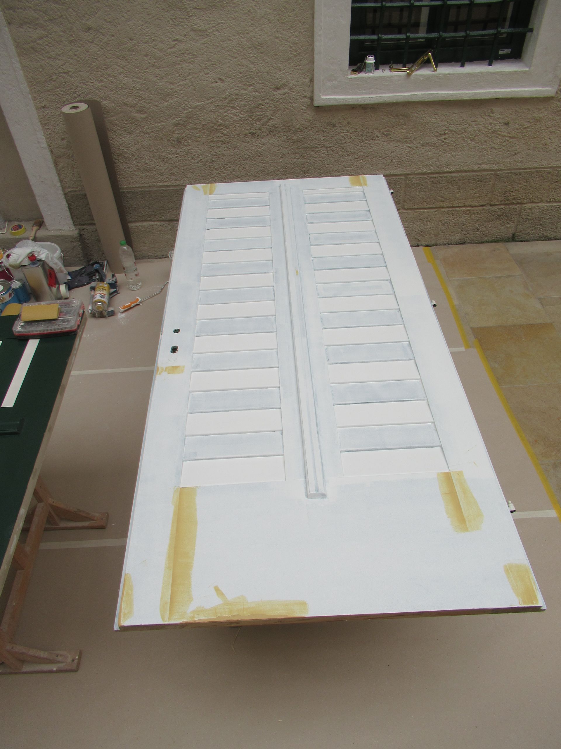 Eine grüne Tür mit weißen Streifen wird gestrichen