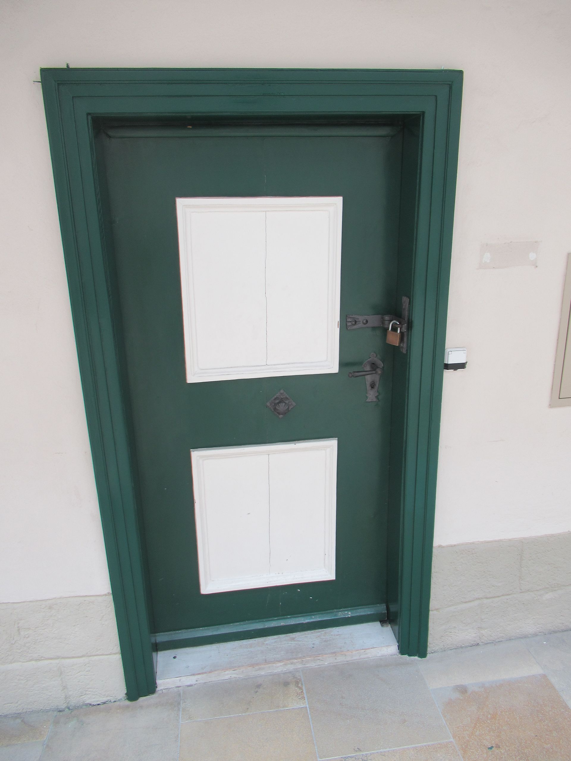 Eine grüne Tür mit zwei weißen Quadraten darauf