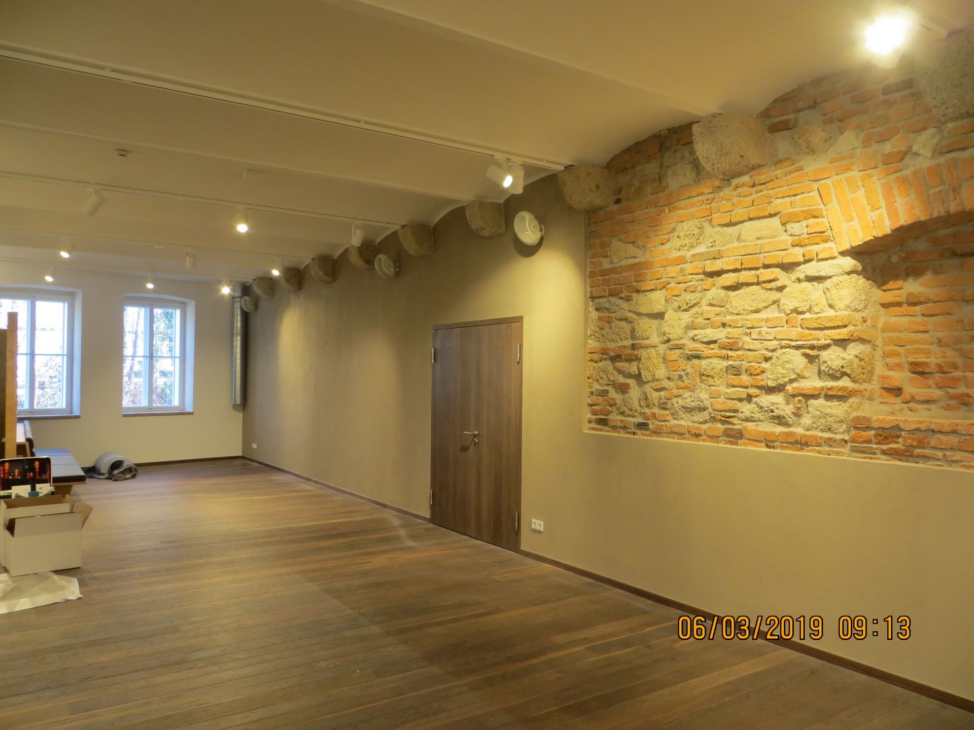 Ein leerer Raum mit einer Ziegelwand und einem Holzboden.