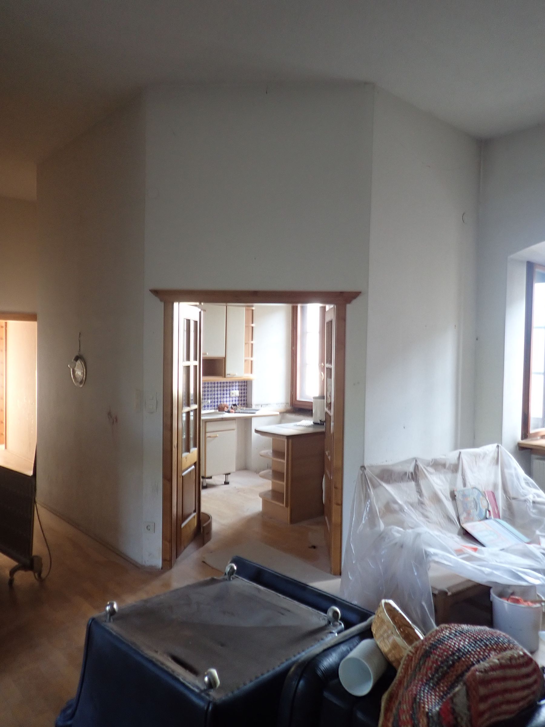 Ein Wohnzimmer mit einer Couch und einem Koffer darin.