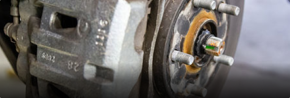 A close up of a brake caliper on a car wheel.  | Protech Auto Group Auto Repair