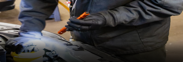 A man wearing blue gloves is working on a motorcycle.  | Protech Auto Group Auto Repair