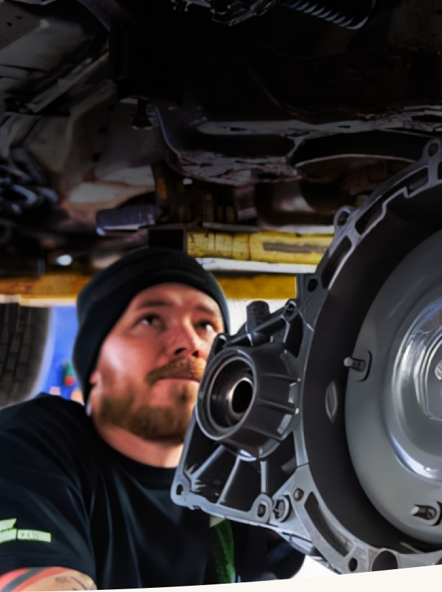 A man in a black shirt is working on a gearbox under a car | Protech Auto Group Auto Repair