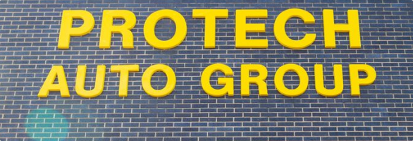 A sign on a brick wall that says protech auto group | Protech Auto Group Auto Repair