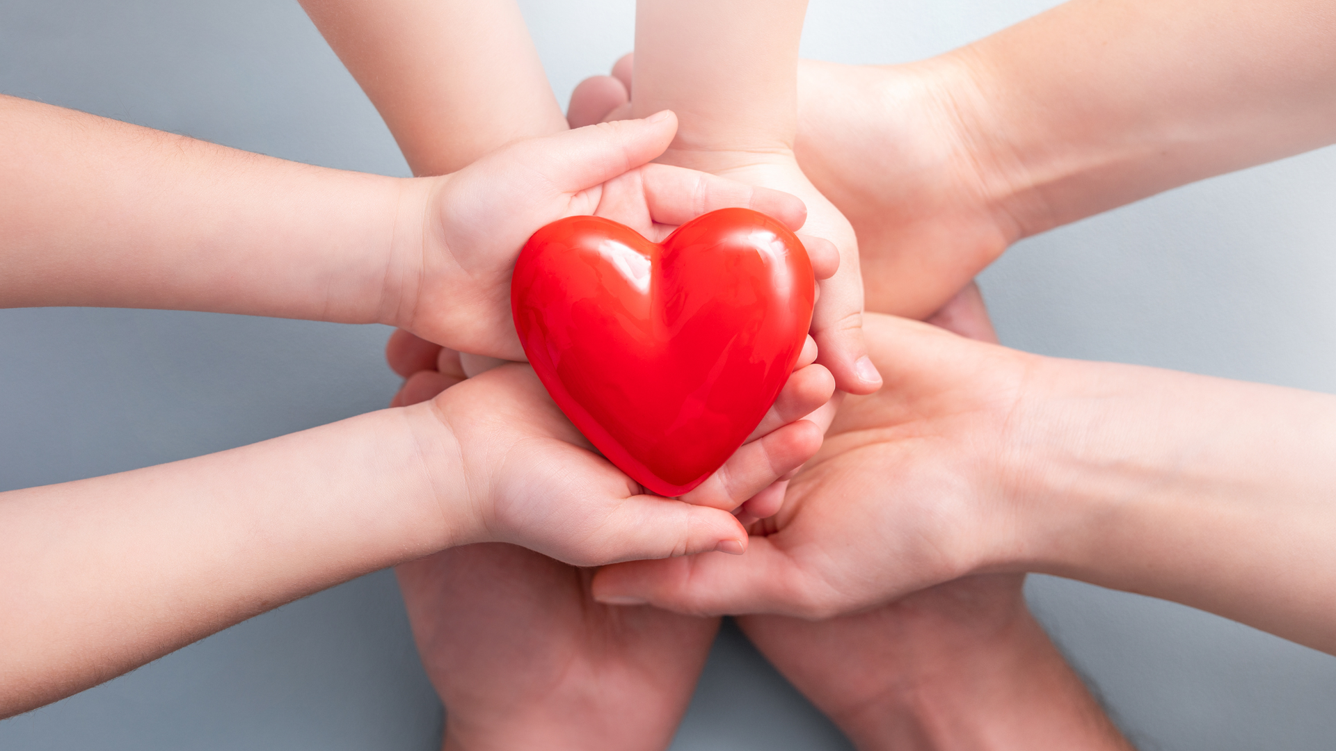 family hands holding a heart