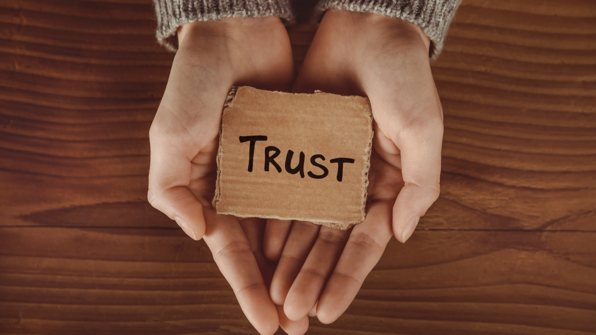 hands holding a trust sign in their palm