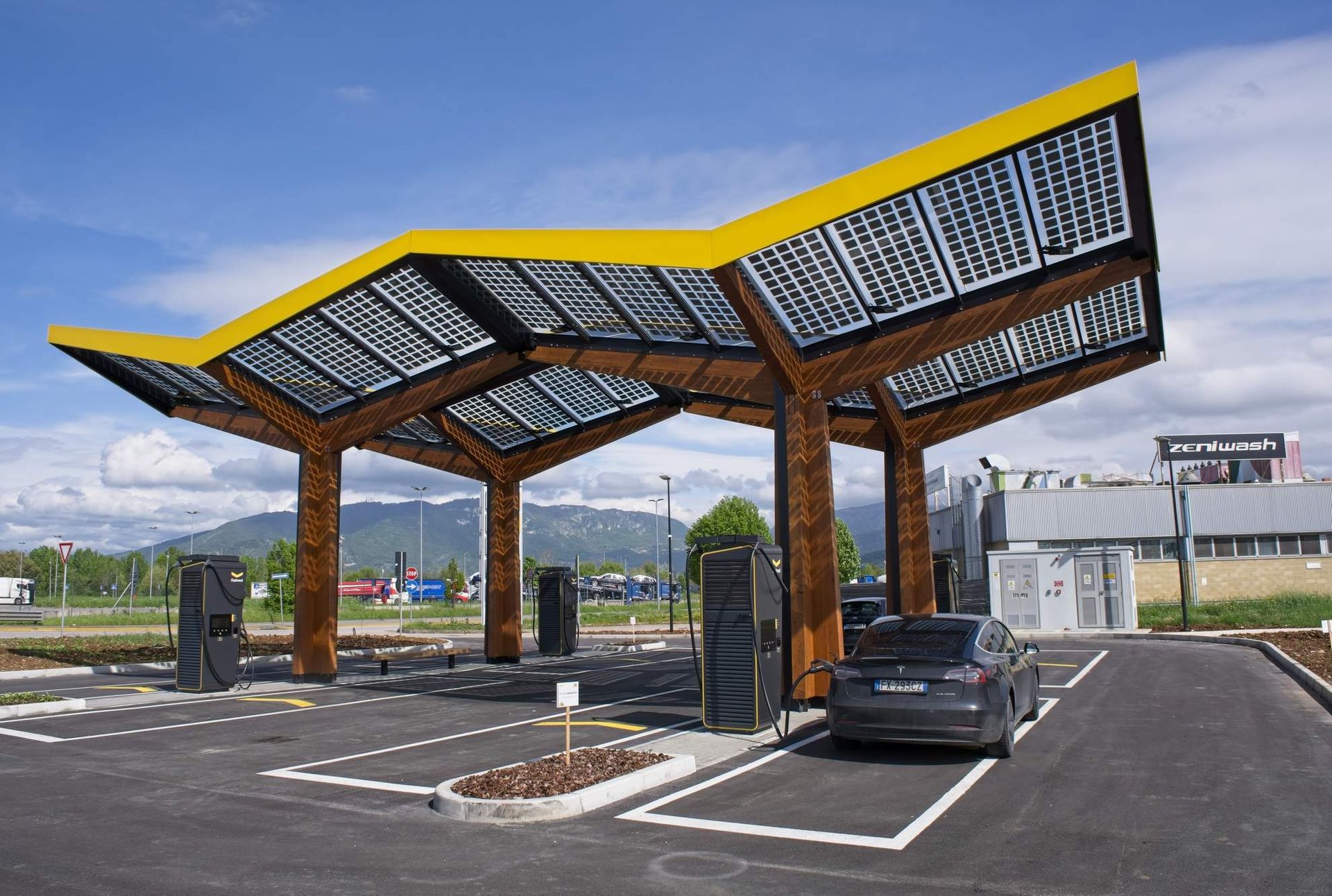 Gezin naast een zwart karretje voor een achtbaan, klaar om naar het pretpark te gaan.