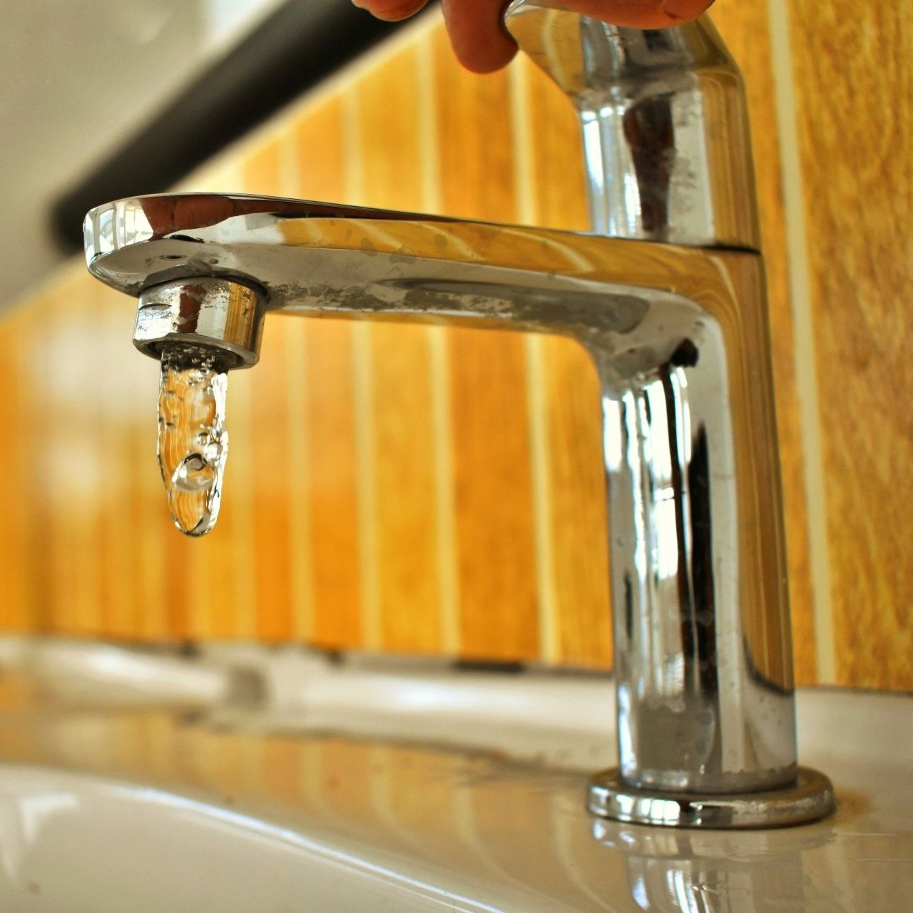 a faucet with a drop of water coming out of it