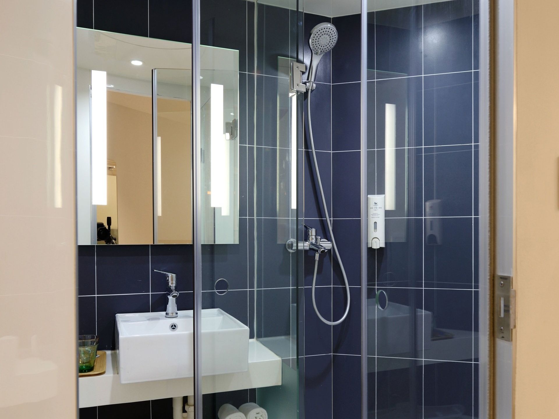 a bathroom with blue tiles and a sink and shower