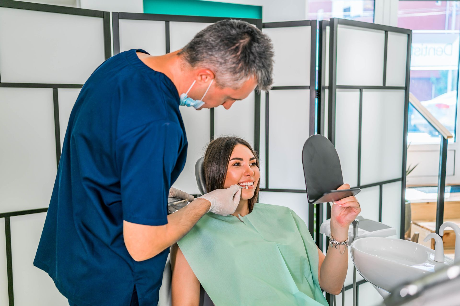 A woman in a dental chair as a dentist checks her teeth, showing how crowns restore tooth strength.