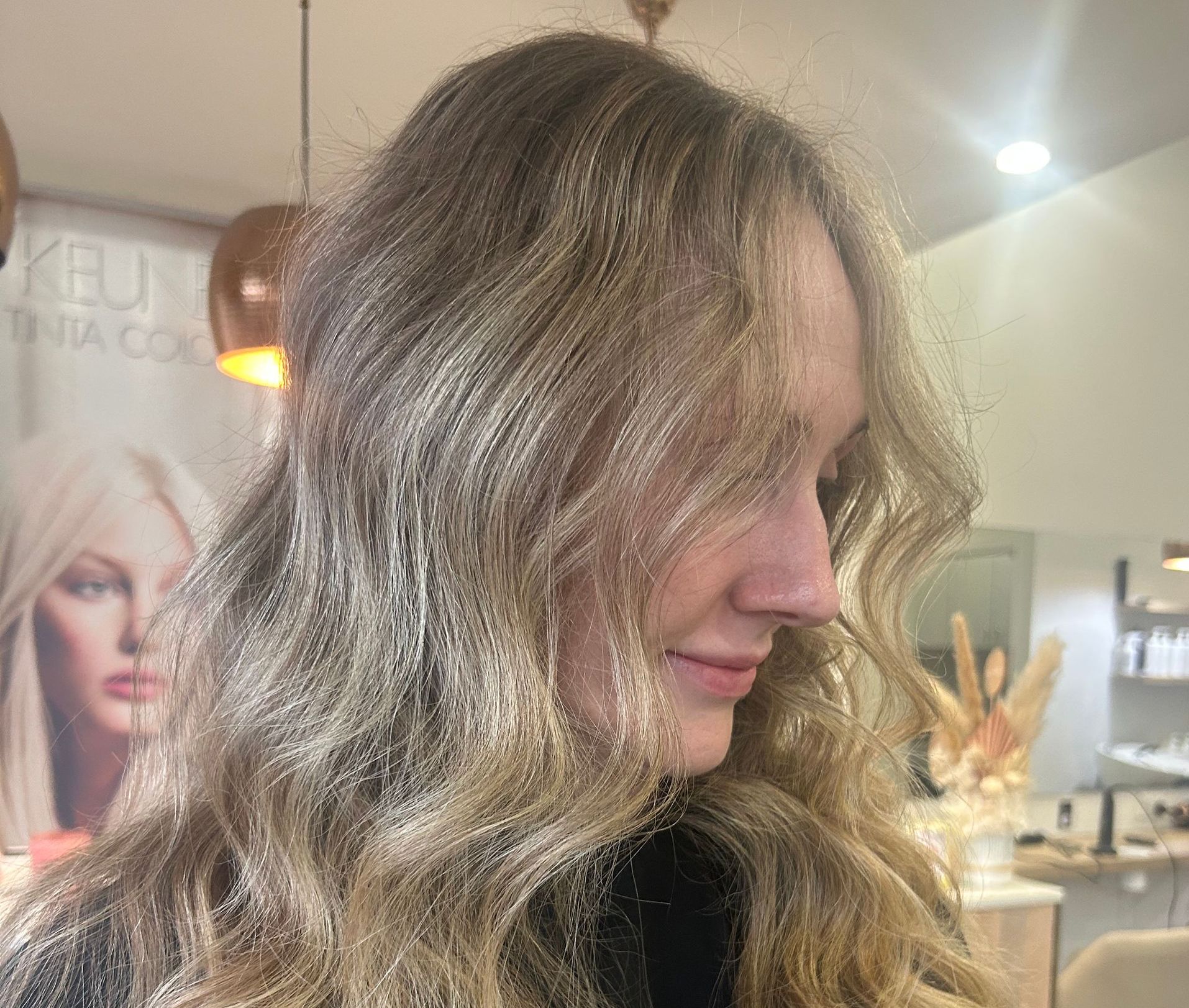 A Woman With Long Blonde Hair is Standing in a Salon — Hair By Jell In Cannonvale, QLD