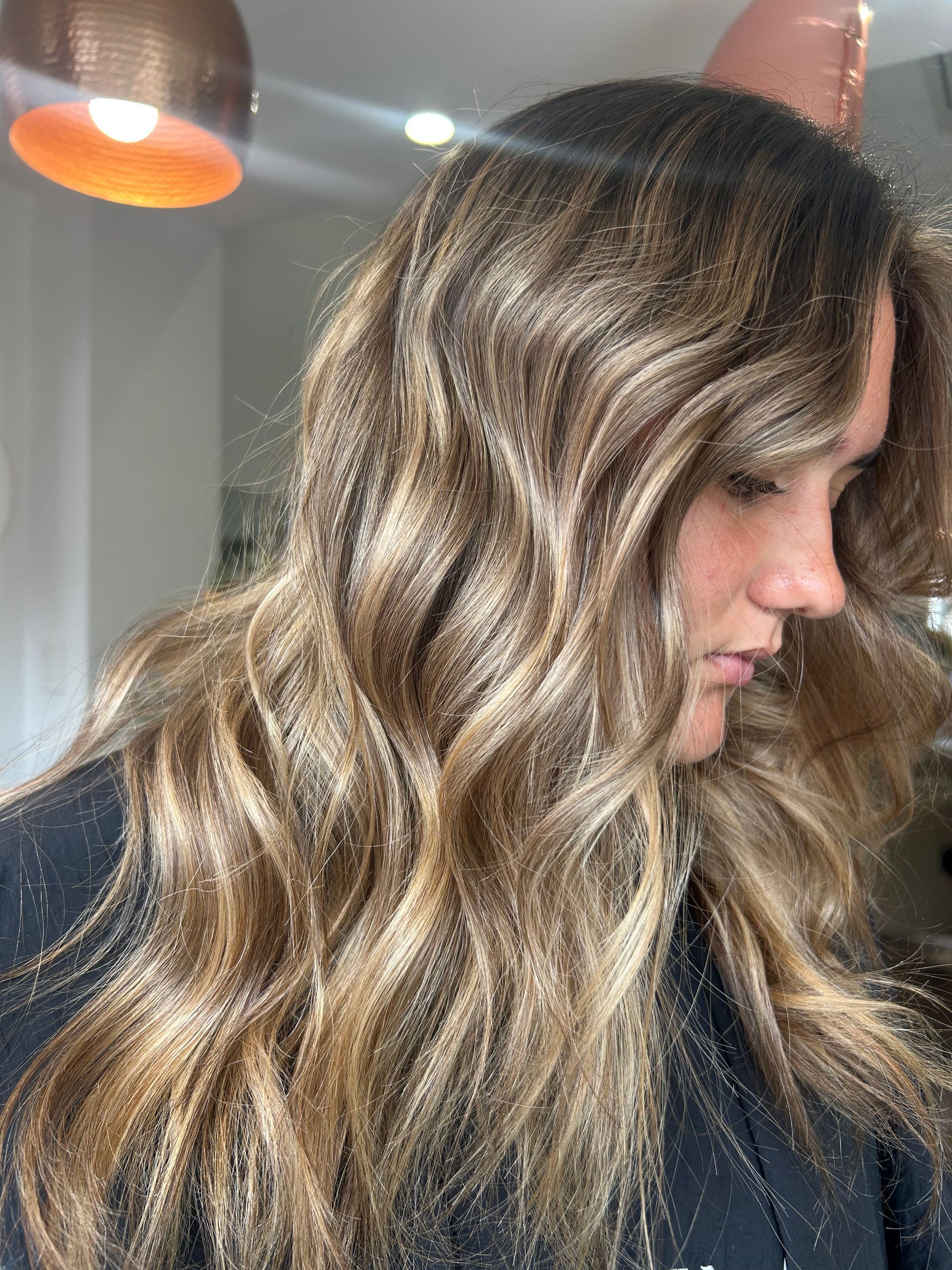 A Woman With Blonde Hair is Wearing a Black Shirt With a Paw Print on It — Hair By Jell In Cannonvale, QLD