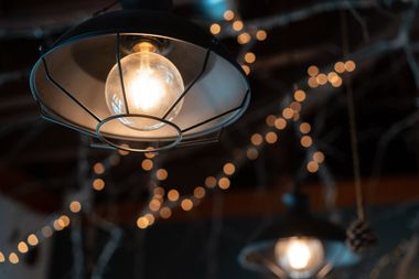 Warm hanging bulbs glowing against a dark background with blurred string lights.
