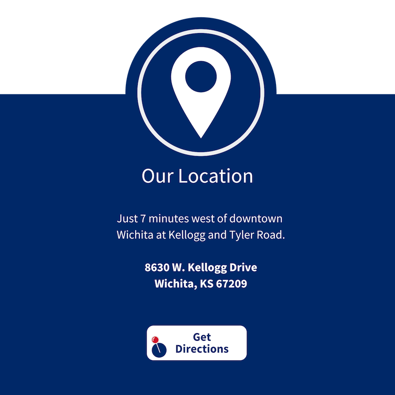 A blue sign that says our location is 7 minutes west of downtown wichita at kellogg and tyler road