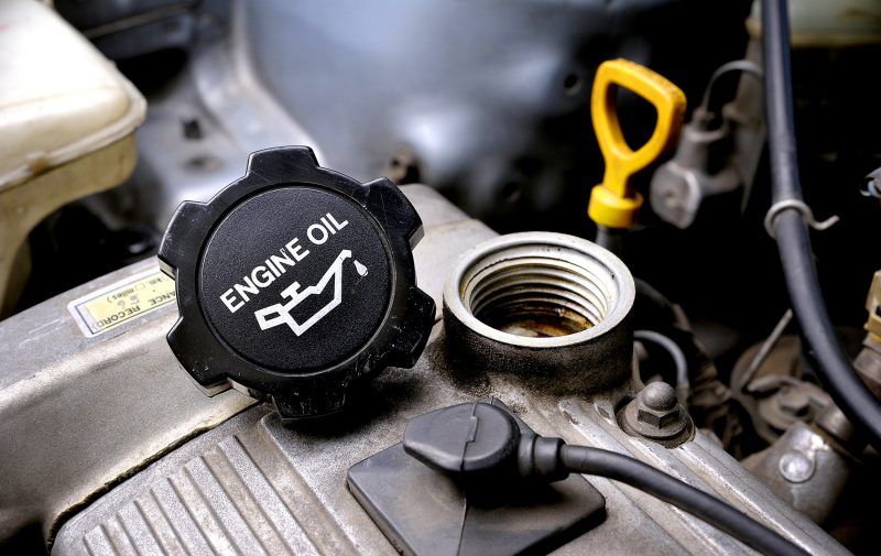 A close up of an engine oil cap on a car engine.
