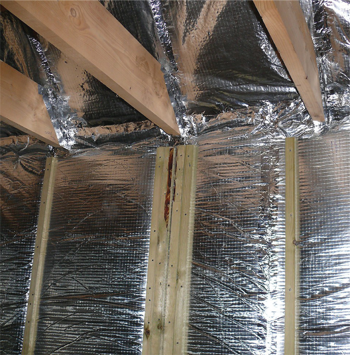 A room with aluminum foil and wooden beams