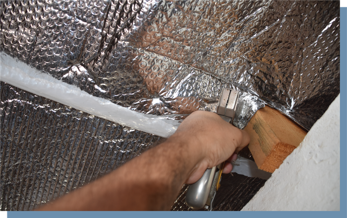 A person is working on a piece of aluminum foil.