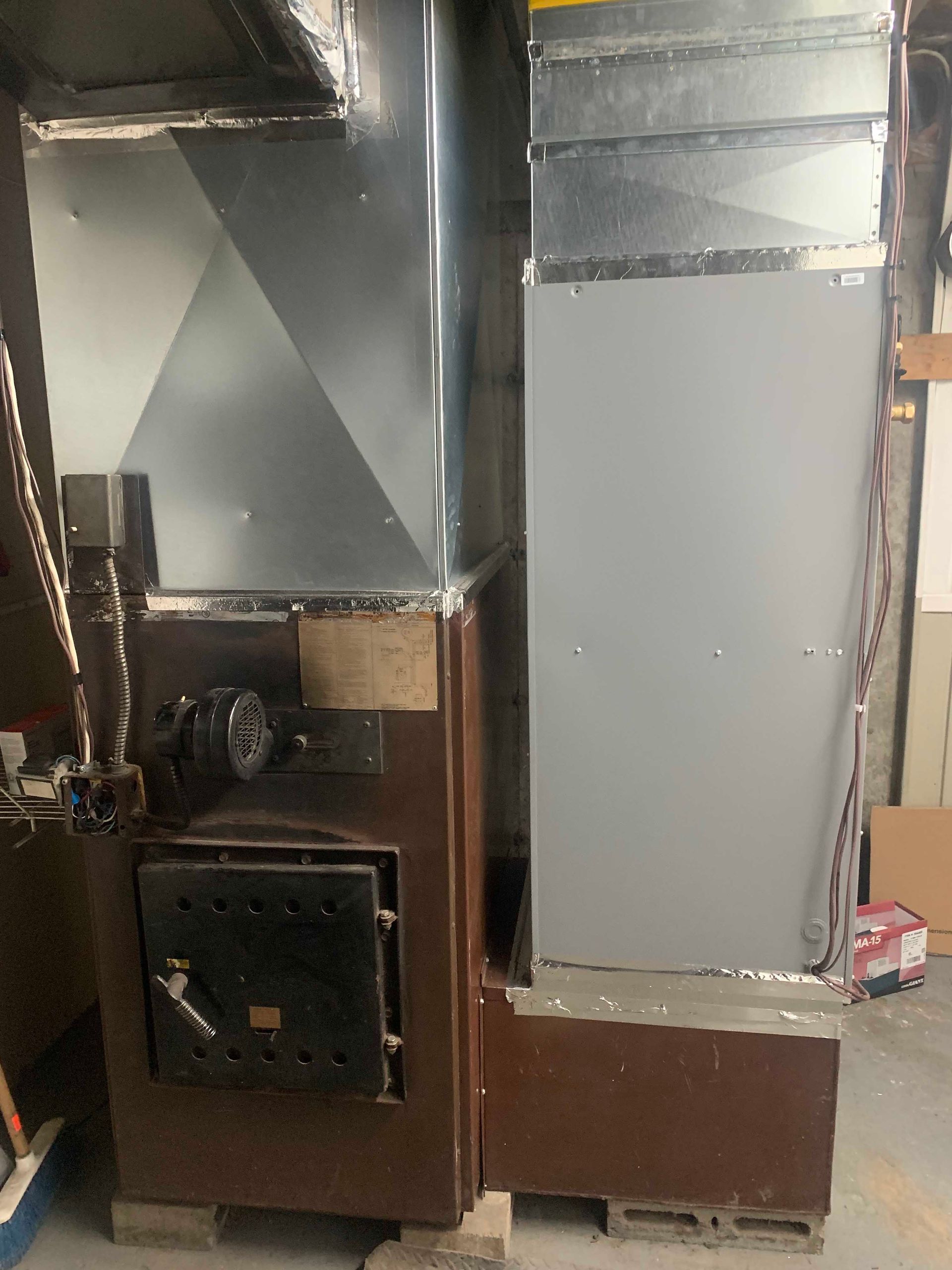 Four métallique avec conduit d'évacuation et porte, brun et argent, dans un environnement industriel.