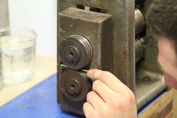 Rolling the D shaped wire to make the wedding band.