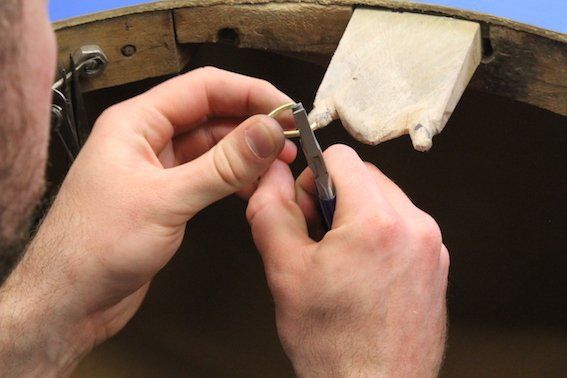 Making the metal into a circle, using a pair of half round pliers.