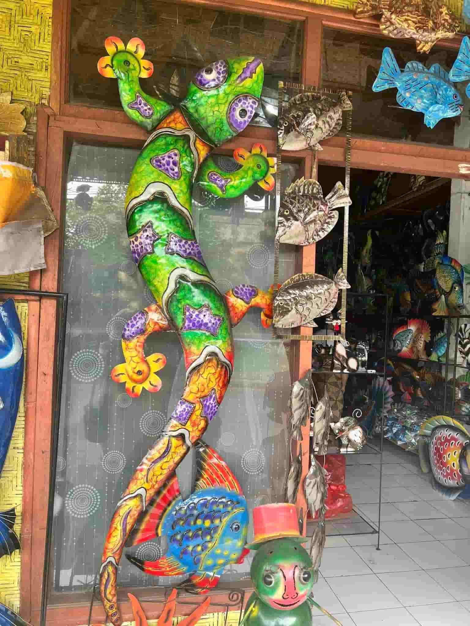 A Colorful Statue of a Lizard is Standing in Front of a Store