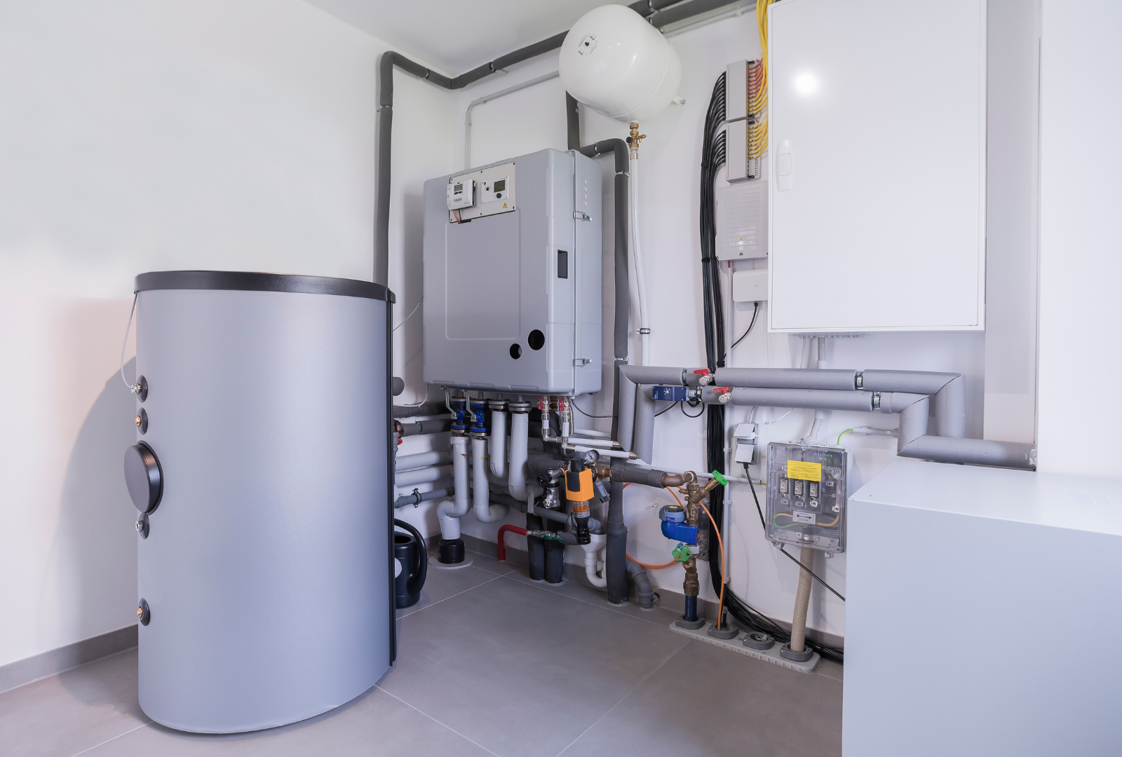 Utility room with water heater, pipes, and electrical panels against white walls