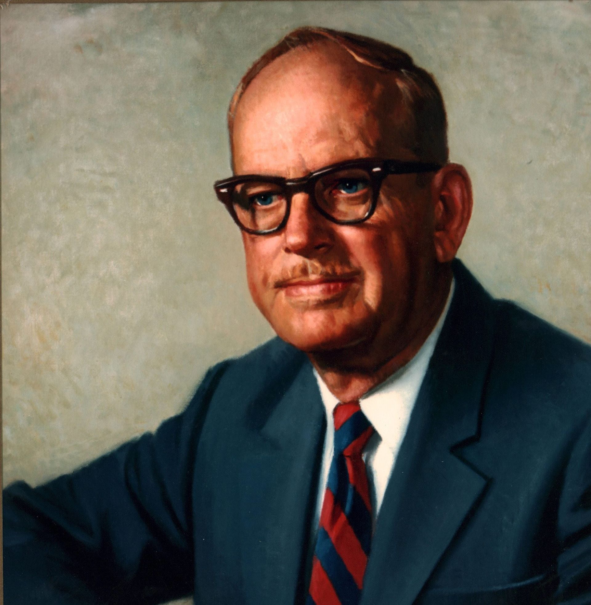 A man in a suit and tie with glasses and a mustache