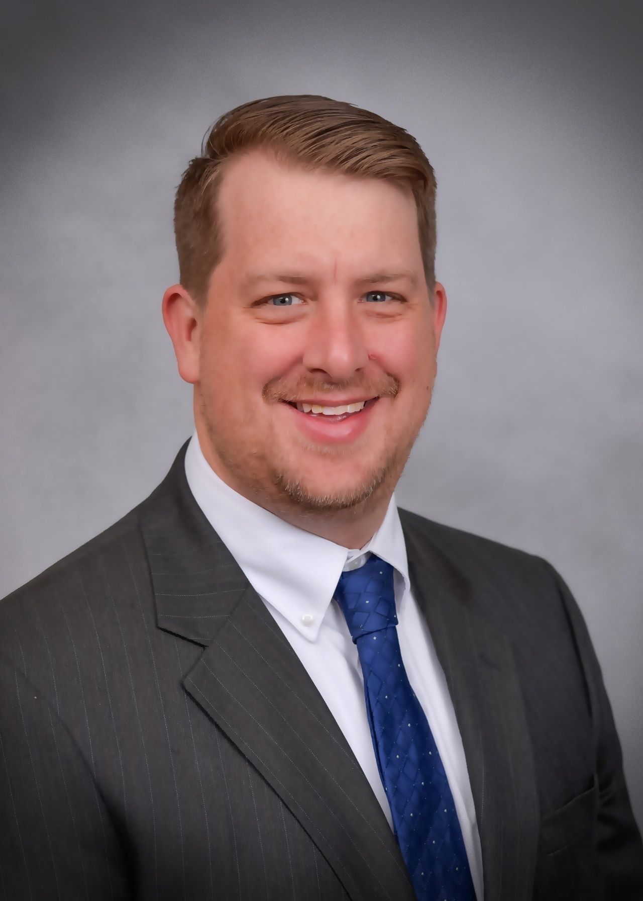 A man in a suit and tie is smiling for the camera.
