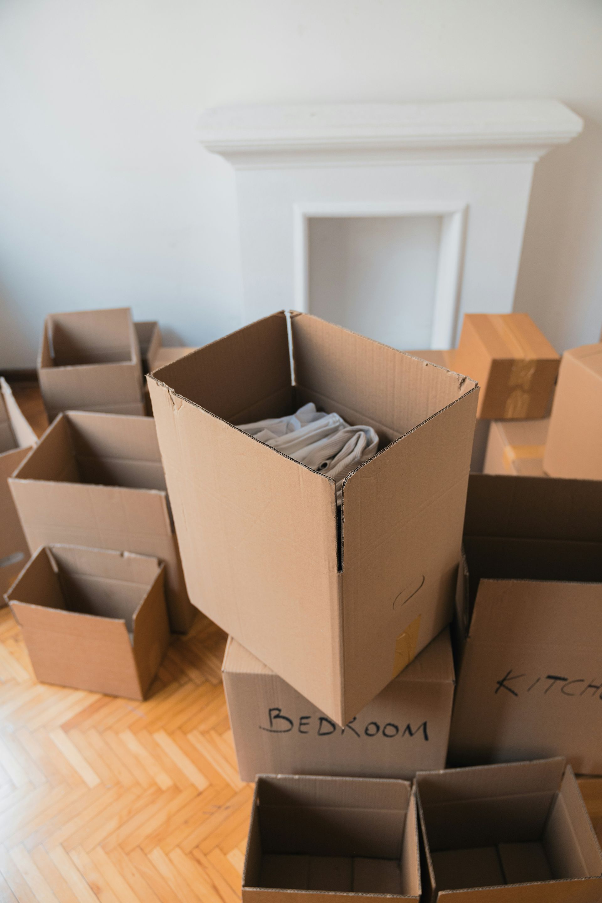 A pile of cardboard boxes are stacked on top of each other in a living room.
