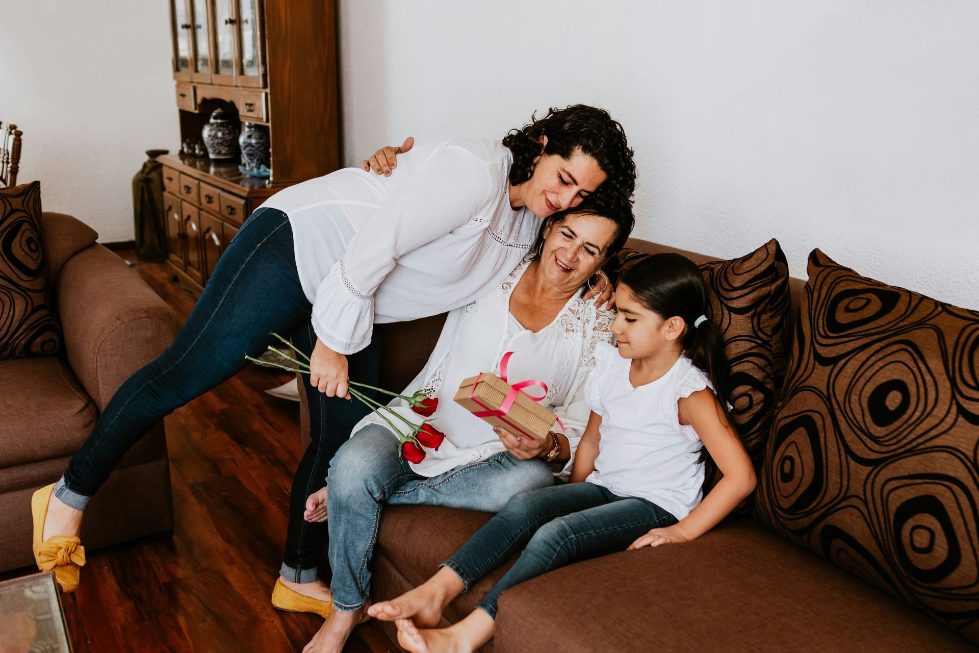 A family is sitting on a couch in a living room.