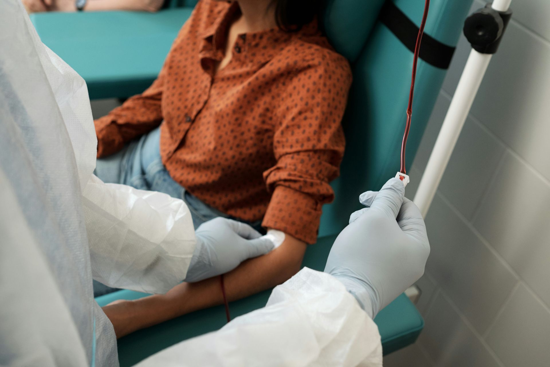 A woman is getting an injection in her arm in a hospital.