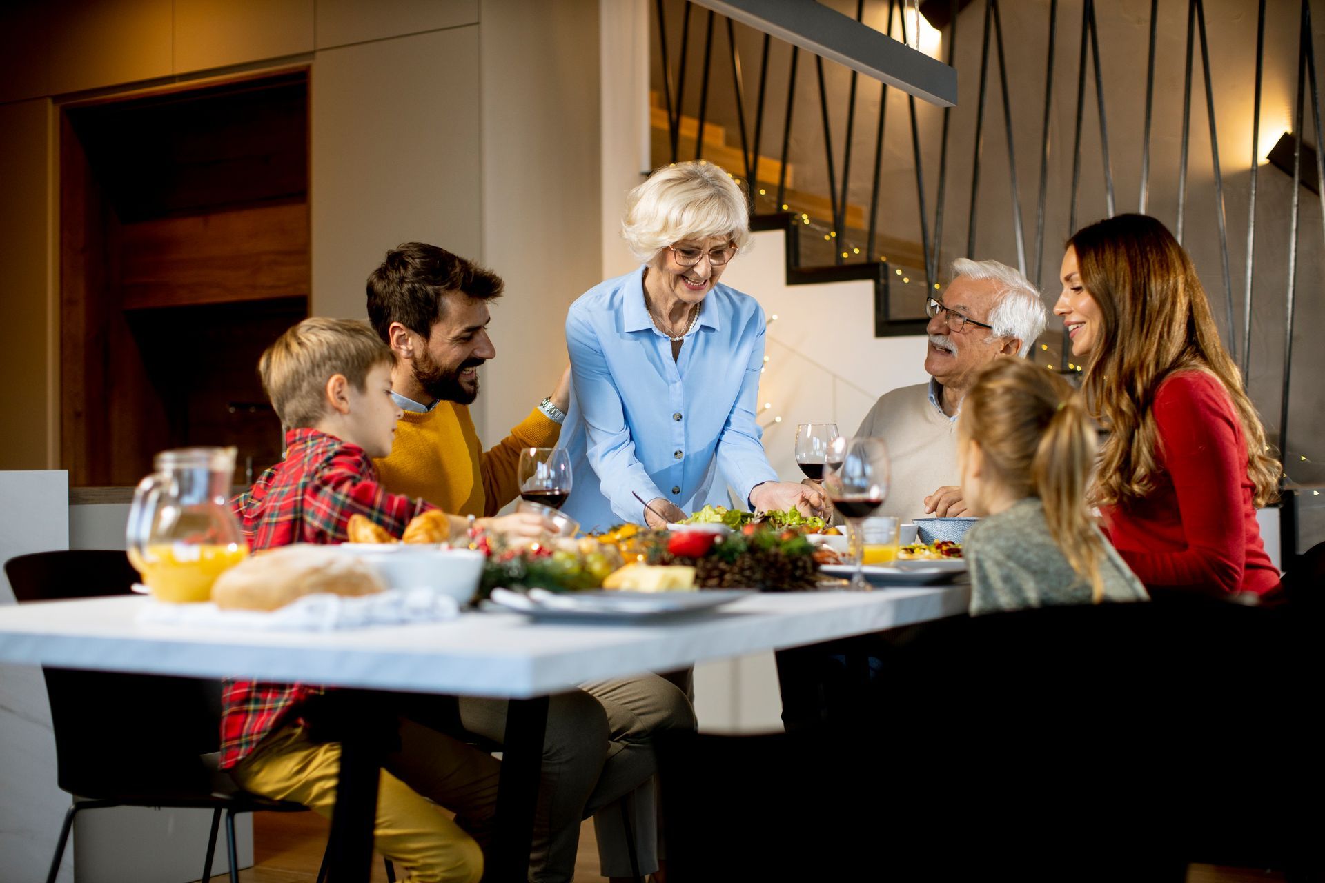 A family is sitting around a table eating food.
