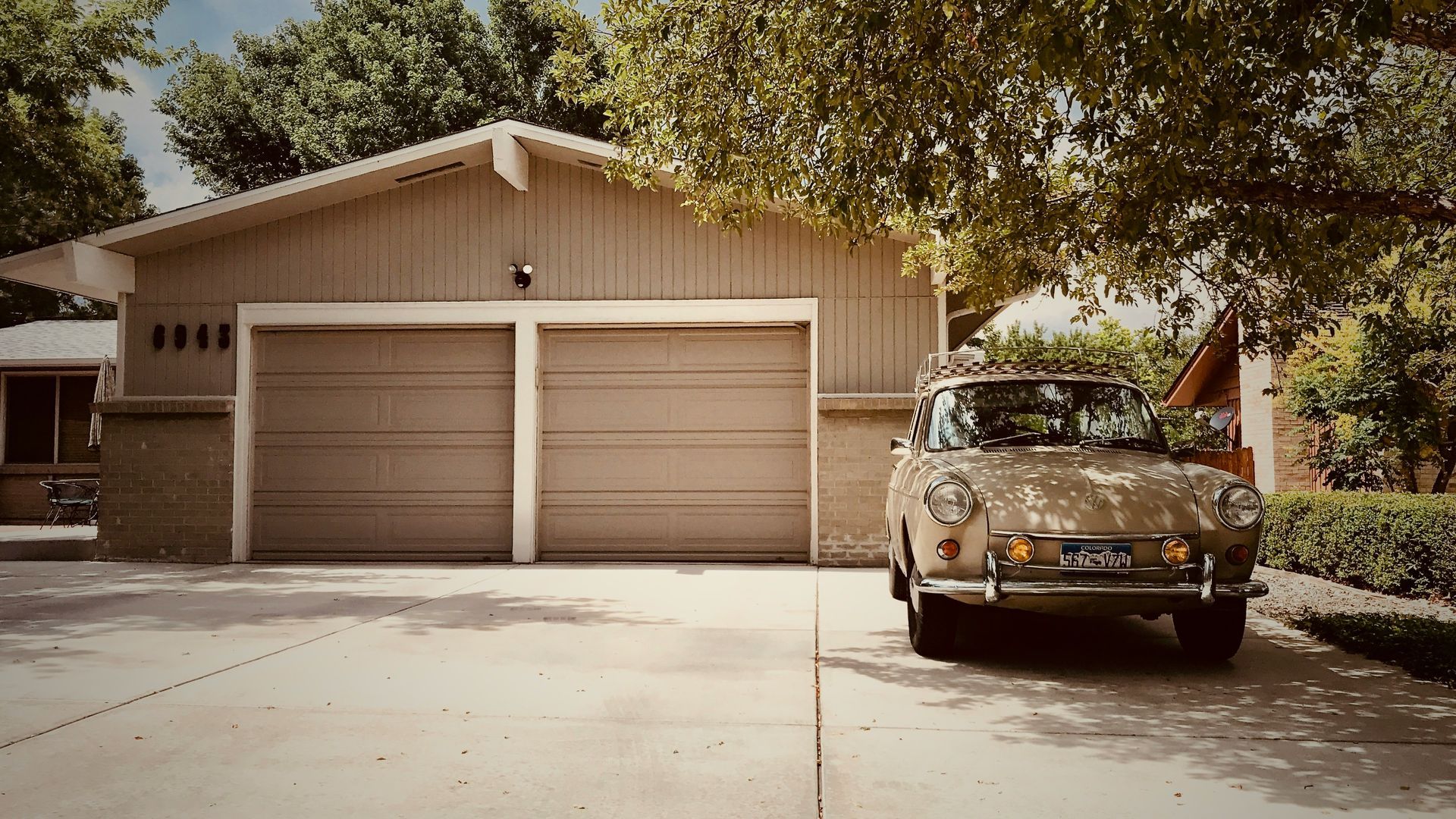 A car is parked in front of a house with a garage