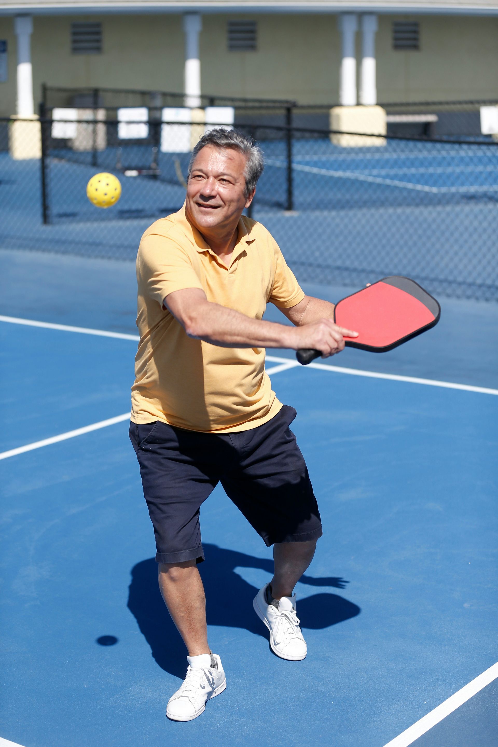 A man is playing paddle tennis on a blue court