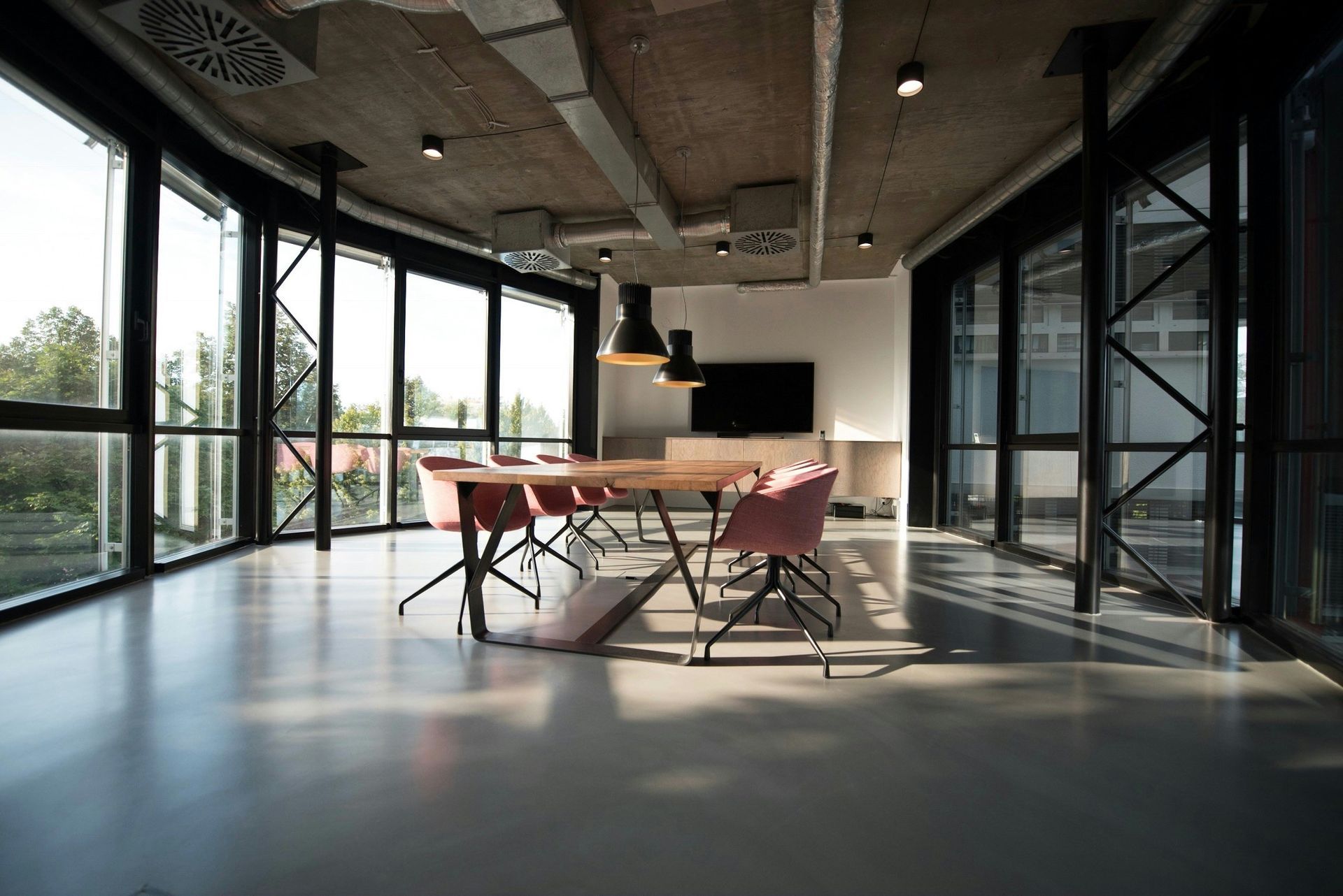 A large conference room with a table and chairs and lots of windows.