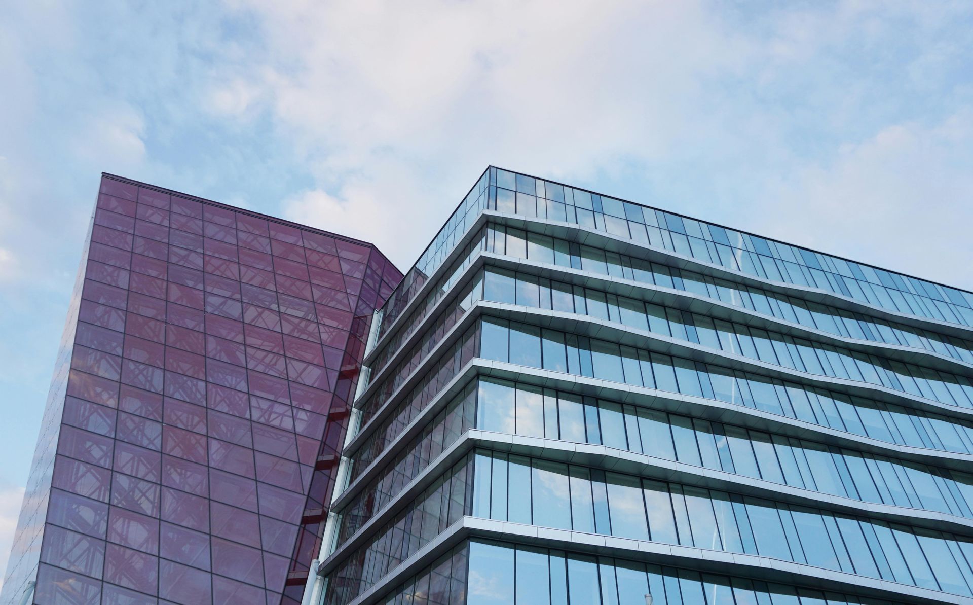 A tall building with a lot of windows and a blue sky in the background.