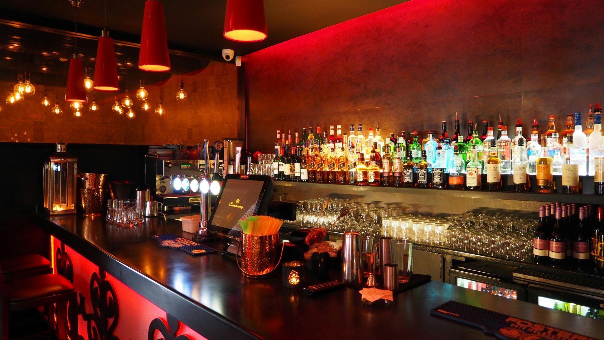 A bar filled with lots of bottles and glasses