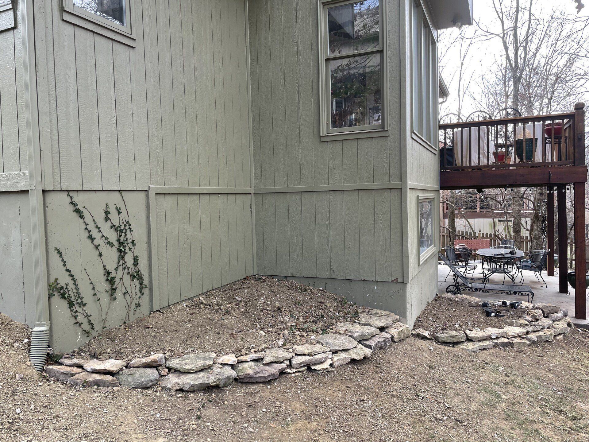 A house with a deck and a stone walkway in front of it.