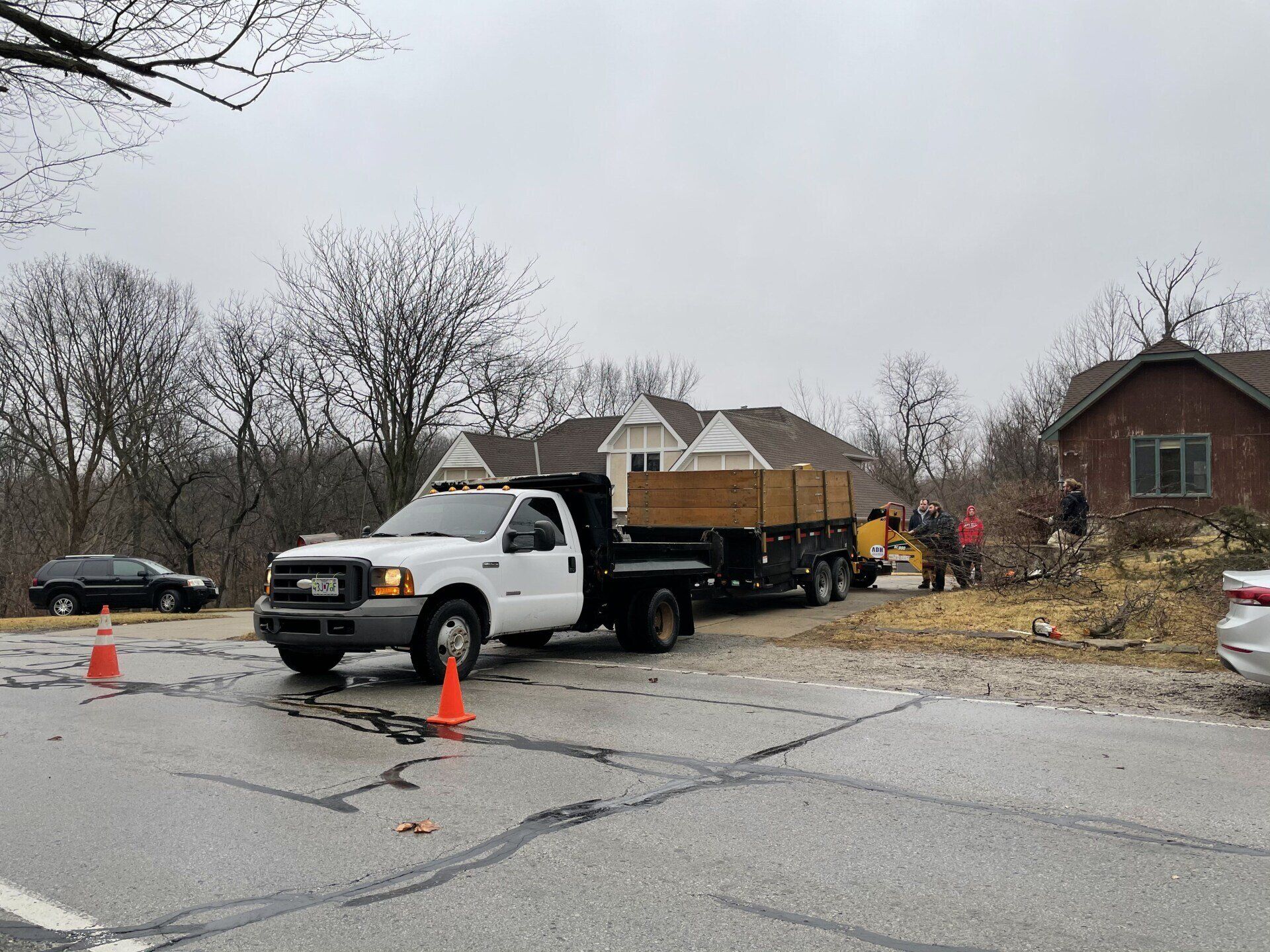 A white truck is parked on the side of the road next to a house.